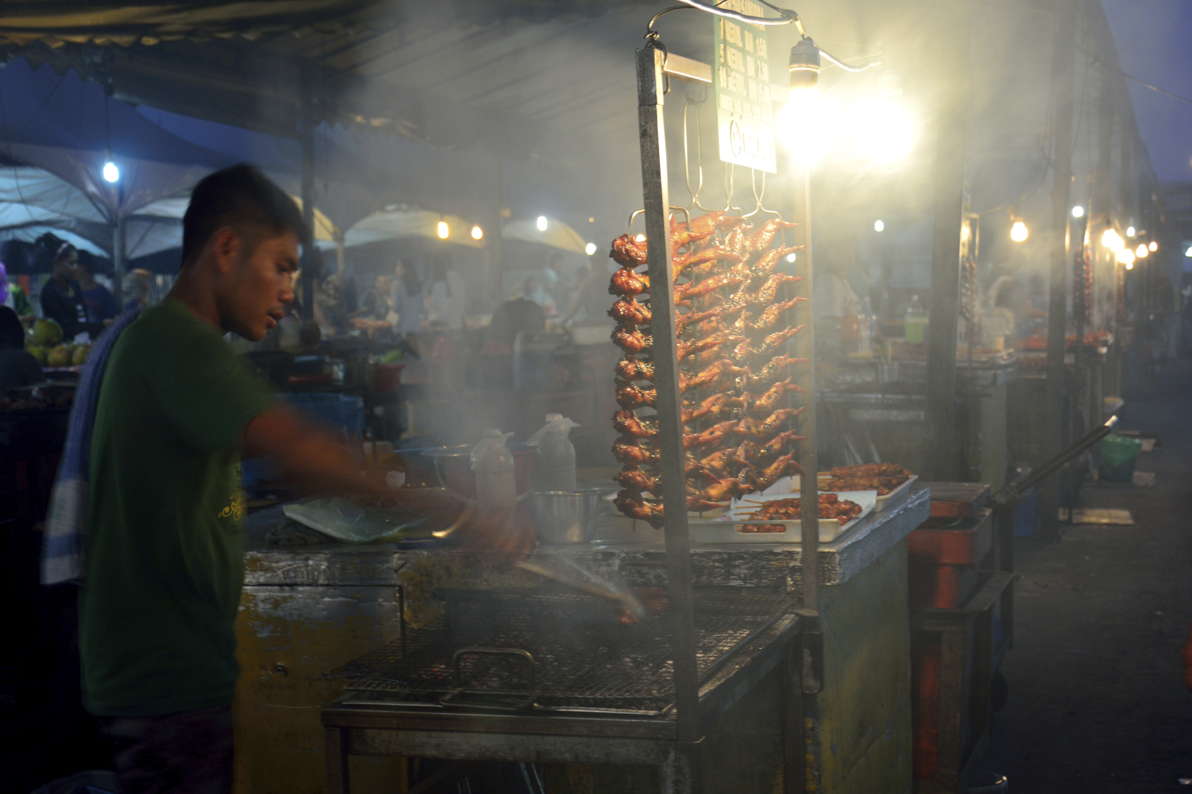 Kota Kinabalu, Malaysia--Local people selling BBQ chicken in Kota Kinabalu night market by the seafront in Sabah Borneo Malaysia.