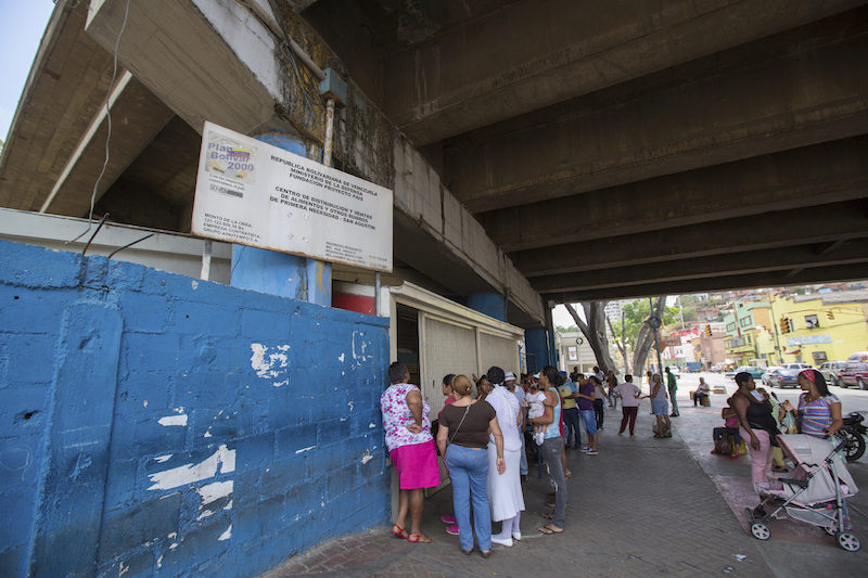 An unidentified group of people waiting in line at a public supermarket doors in Caracas. With significant inflation, rationing is required in some places in Venezuela in 2015 .
